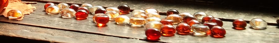 A photo of cloured beads scattered on a wooden step.