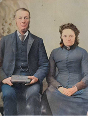 Colourized photograph of a couple seated in fine clothing (1859).
