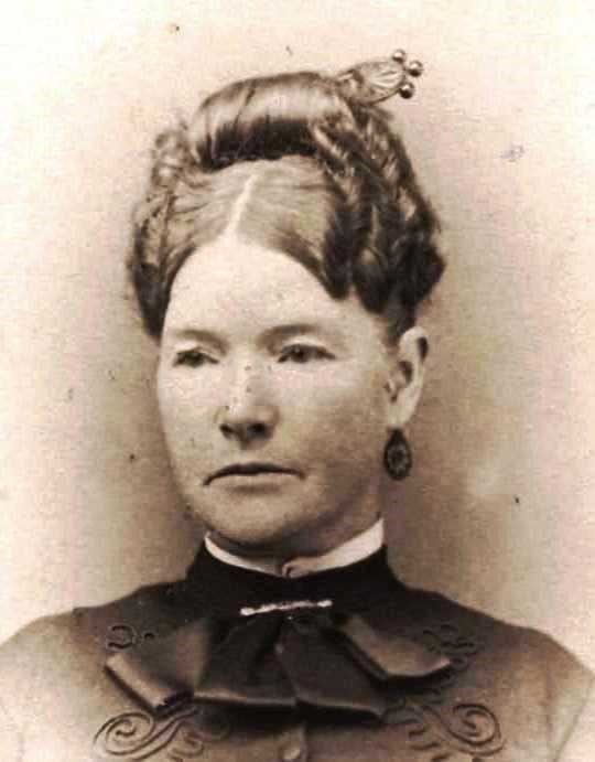 Photographic portrait of a woman (ca. 1880-1900) in fine clothers with hair styled.