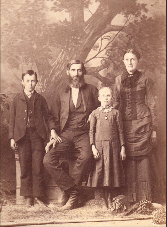 An 1890s family portrait of two older parents with a young boy and girl.