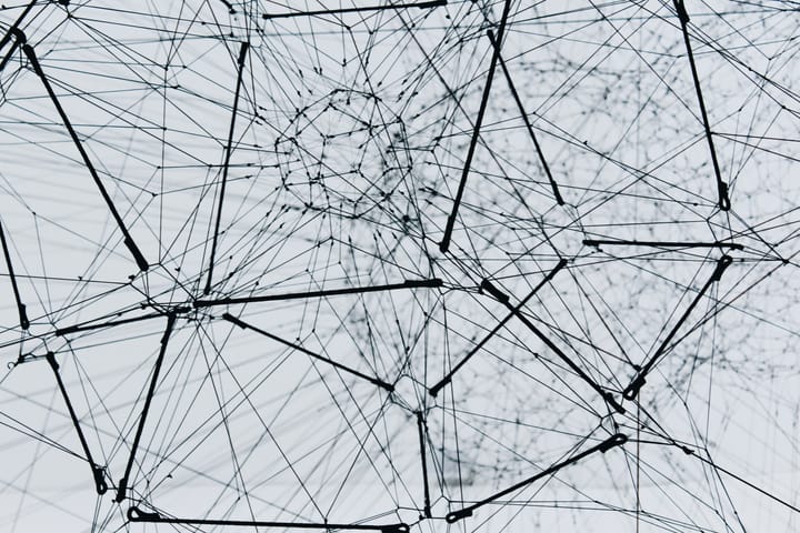 A low-angle view of a metal structure resembling the nodes and connections in a network.
